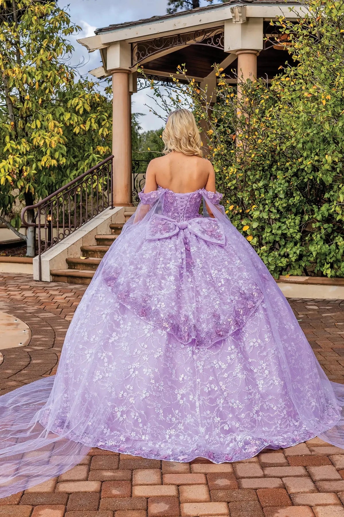 Rear view of a Lilac quinceañera gown showing lace-up back, detachable sleeves, and floral appliqués