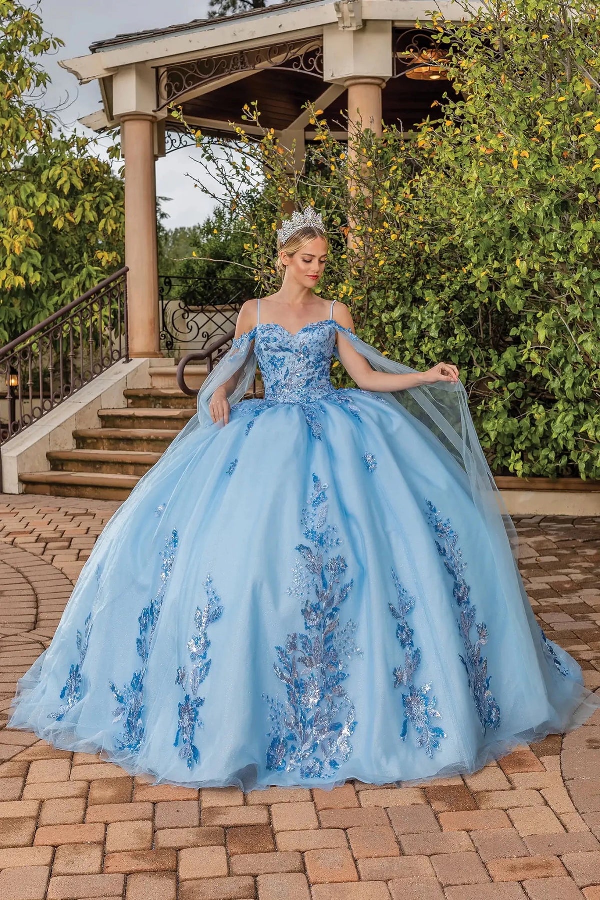 Front view of a Bahama Blue quinceañera gown with spaghetti straps, beaded bodice, and lace-overlay skirt
