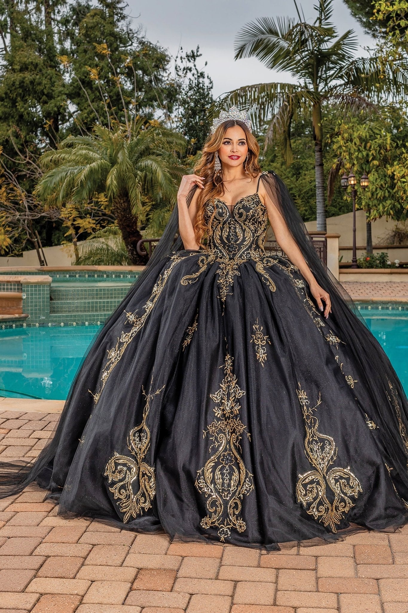 Quinceanera | Black Opulent Embroidered Gold Coiled Off-Shoulder Glittered tulle Ballgown with Dramatic Train - front view of woman wearing dress