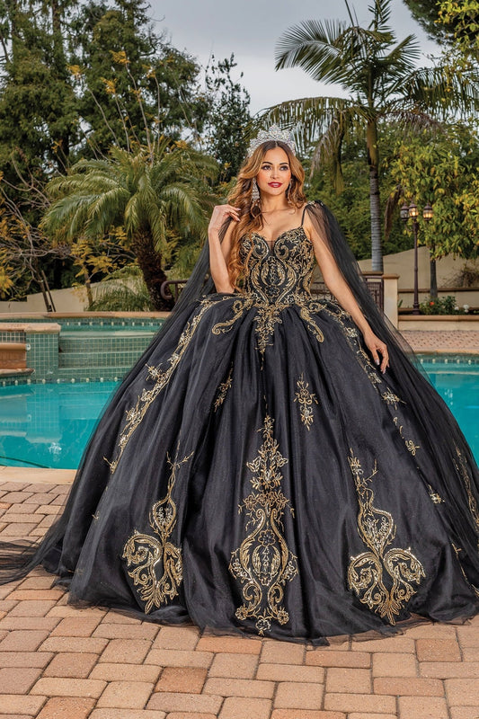 Quinceanera | Black Opulent Embroidered Gold Coiled Off-Shoulder Glittered tulle Ballgown with Dramatic Train - front view of woman wearing dress