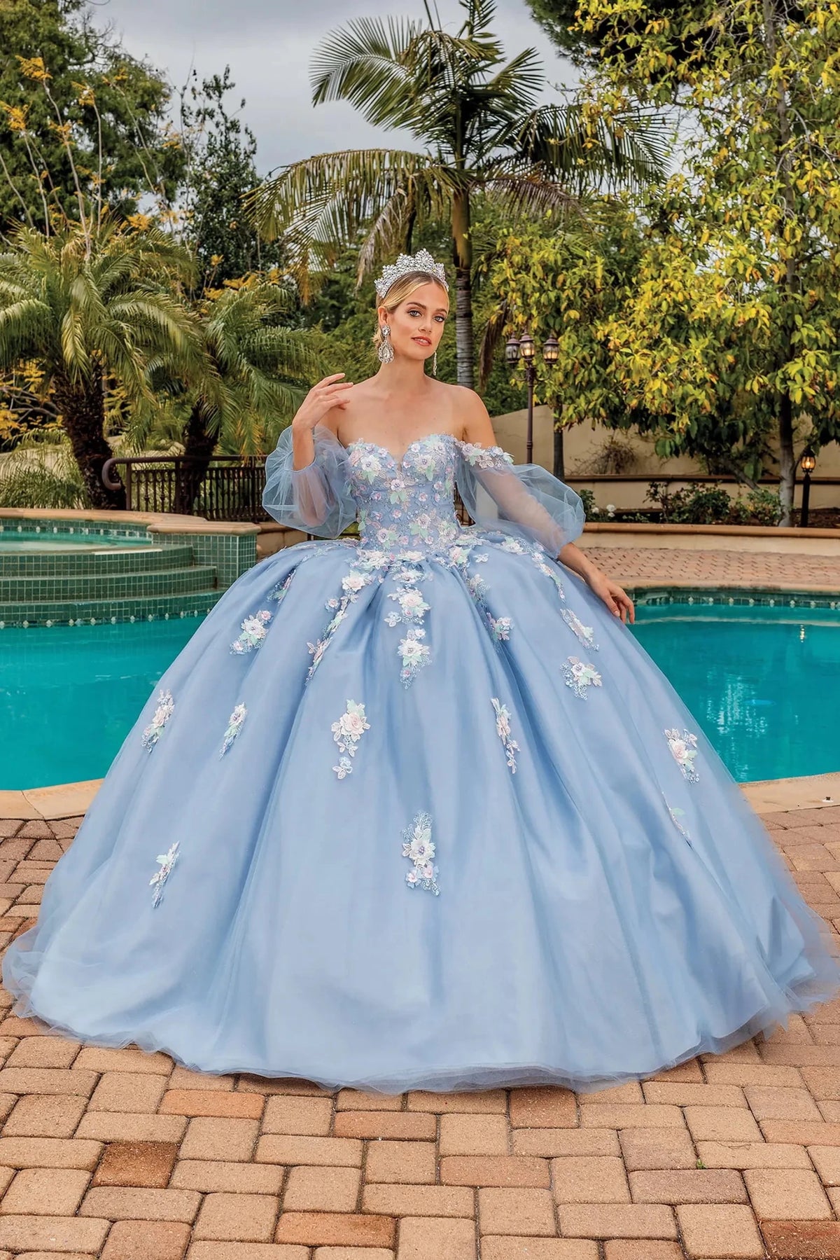 Front view of an Ice Silver quinceañera gown with off-the-shoulder neckline, sheer sleeves, and floral embroidery