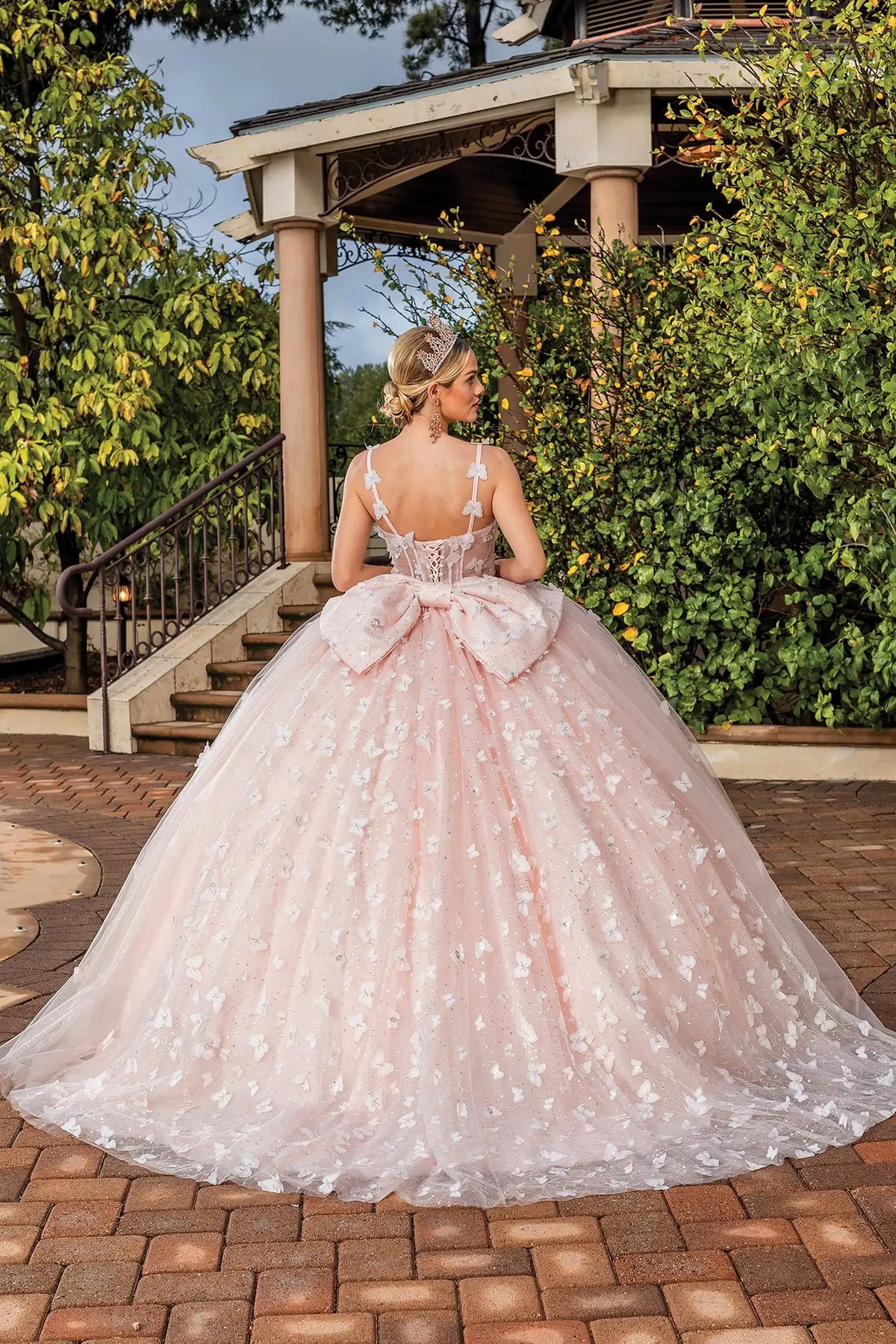 Front view of a Blush quinceañera gown with corset bodice, floral appliqués, and voluminous full skirt