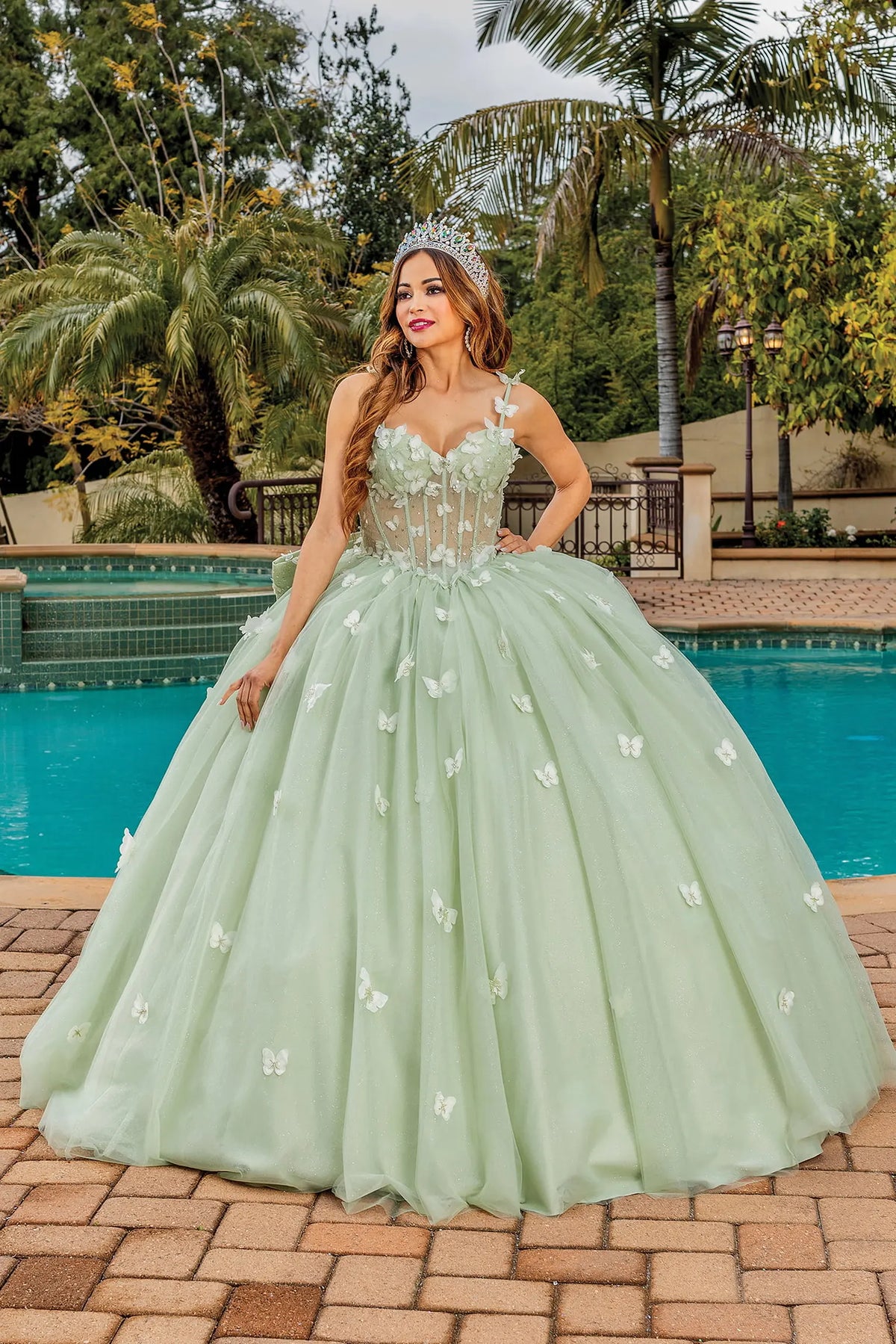 Front view of a Sage quinceañera gown with corset bodice, floral appliqués, and voluminous full skirt