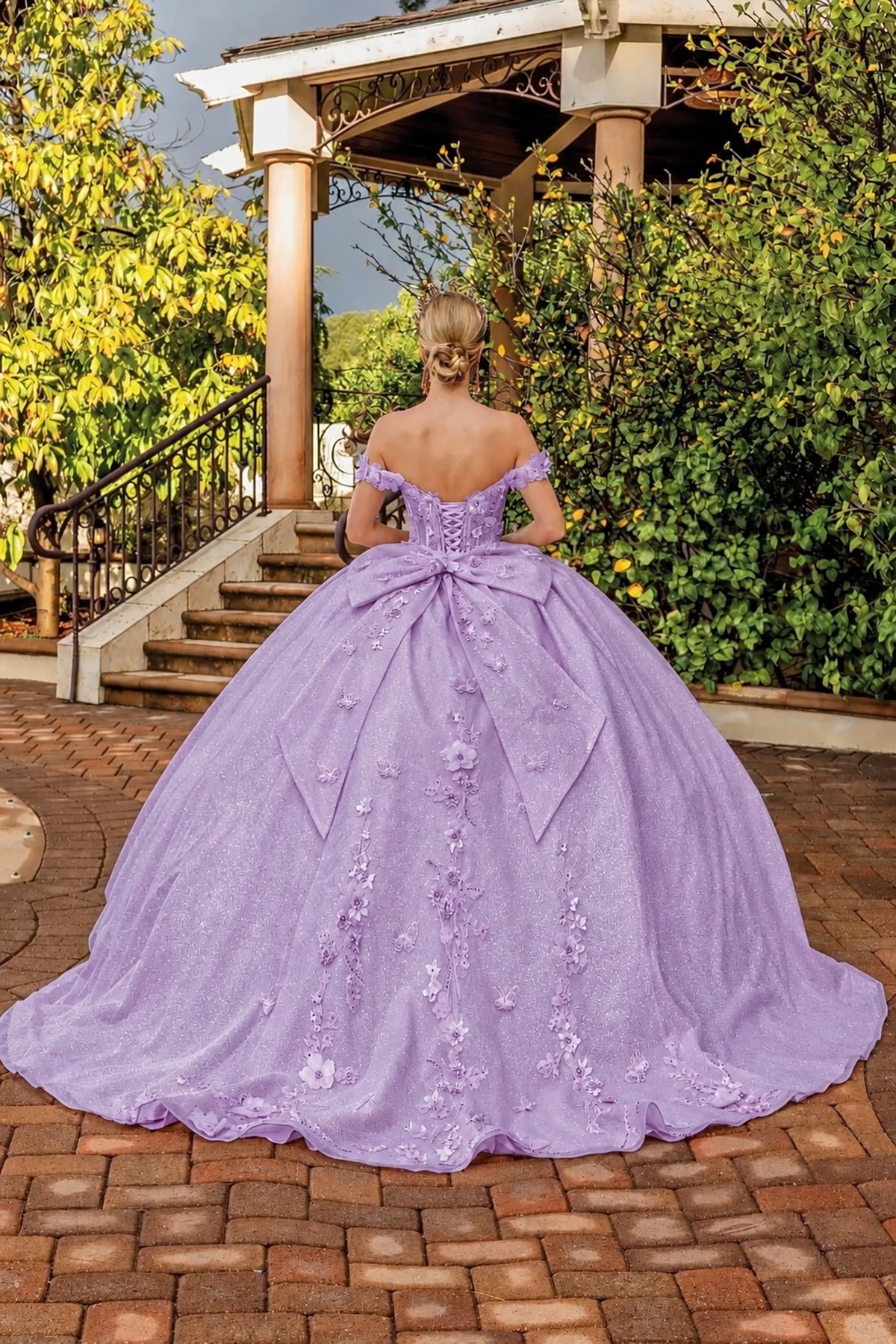 Back view of a Lilac quinceañera gown showing lace-up back and floral appliqués