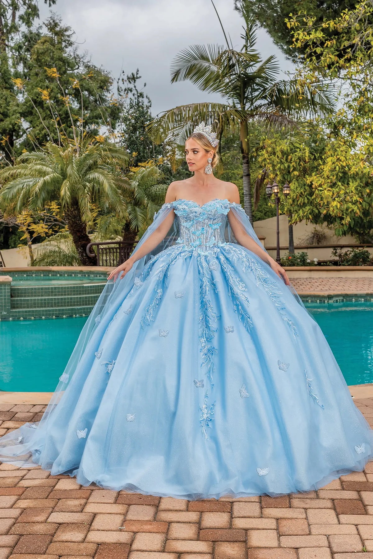 Front view of a Bahama Blue quinceañera gown with off-the-shoulder neckline, beaded bodice, floral embroidery, and full tulle skirt