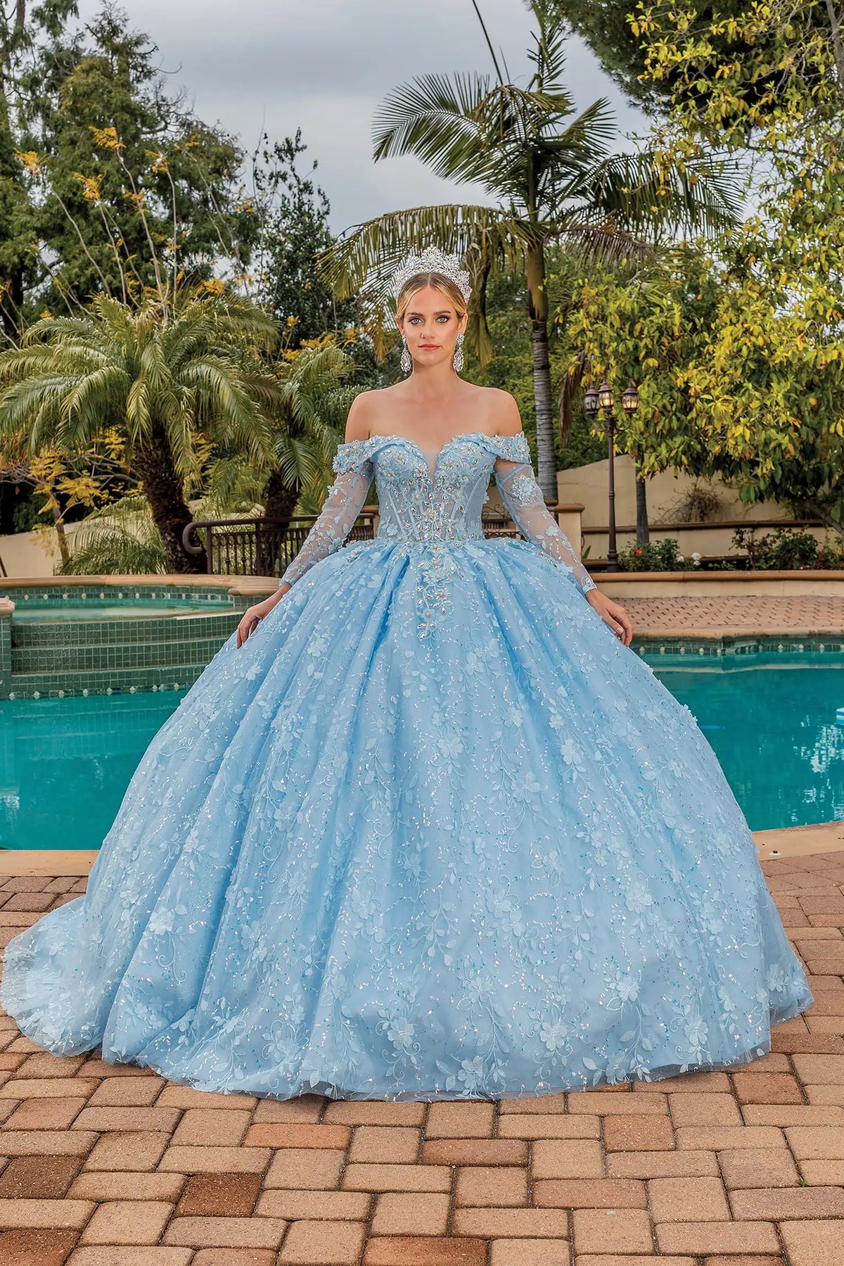 Front view of a Bahama Blue quinceañera gown with off-the-shoulder neckline, long sleeves, and floral appliqués