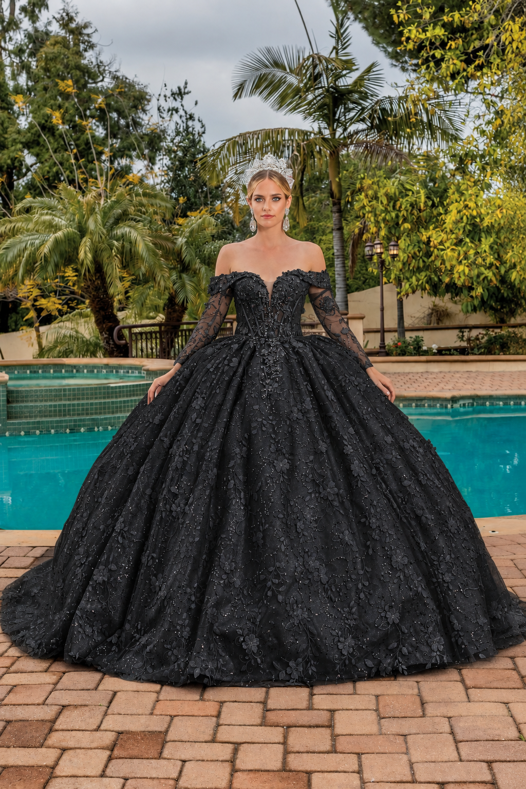Front view of a Black quinceañera gown with off-the-shoulder neckline, long sleeves, and floral appliqués
