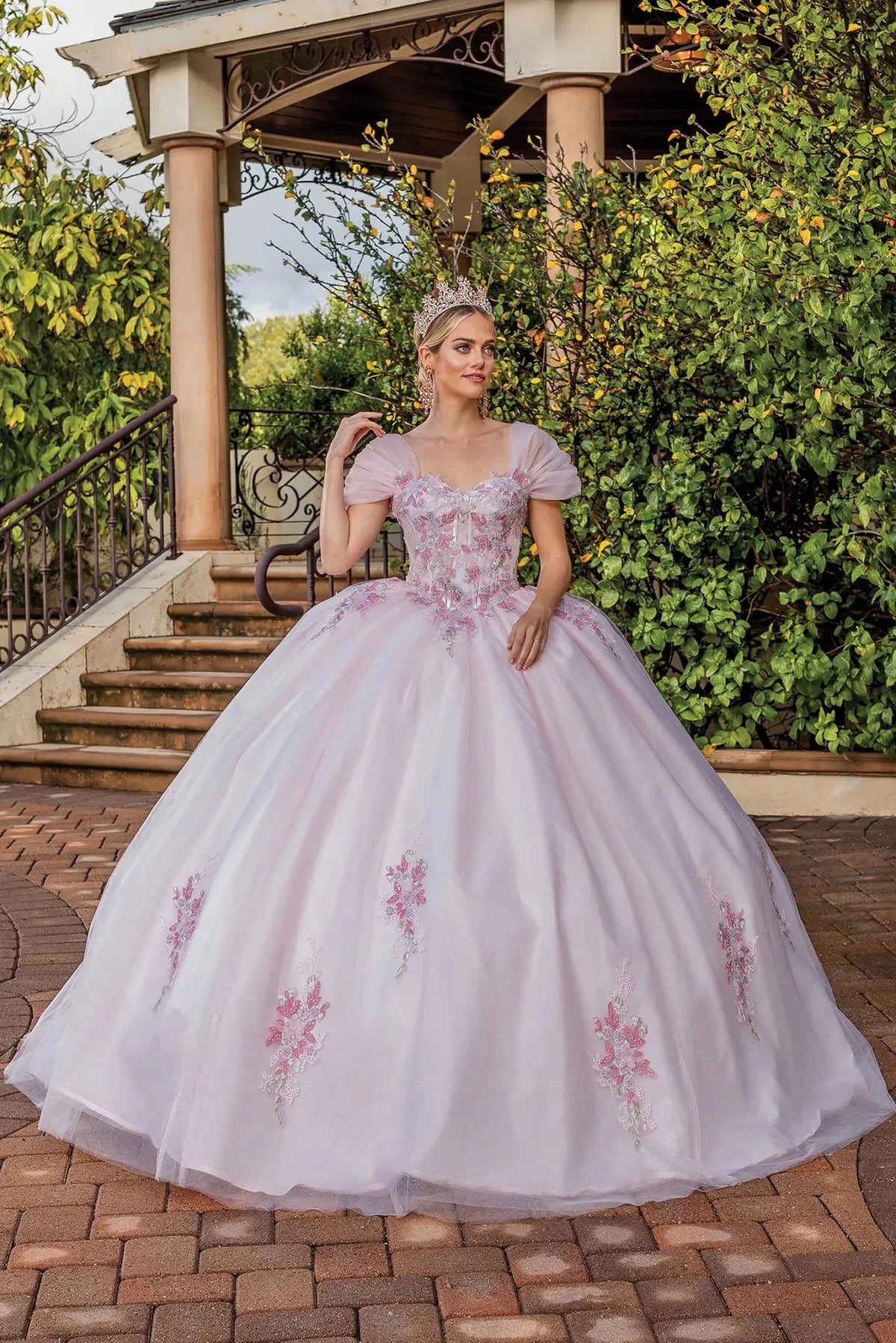 Front view of a Blush quinceañera gown with cap sleeves, floral embroidery, and embroidered tulle skirt