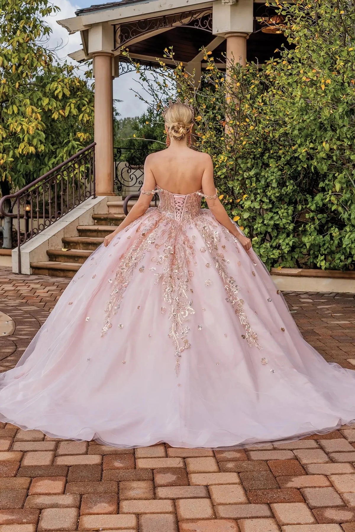 Back portrait of a Blush quinceañera gown showing lace-up back and floral appliqués