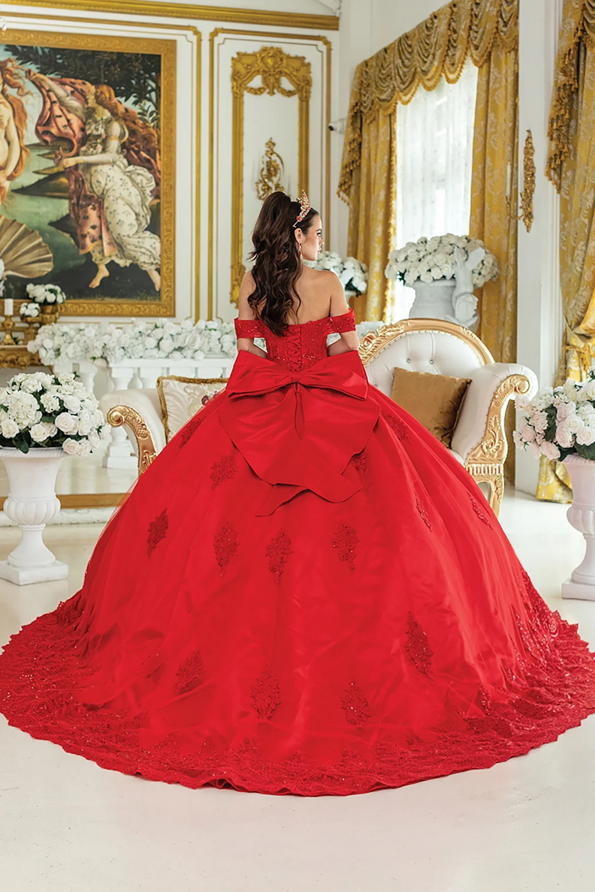 off-the-shoulder red ball gown with a massive bow at the back and a long lace-trimmed train