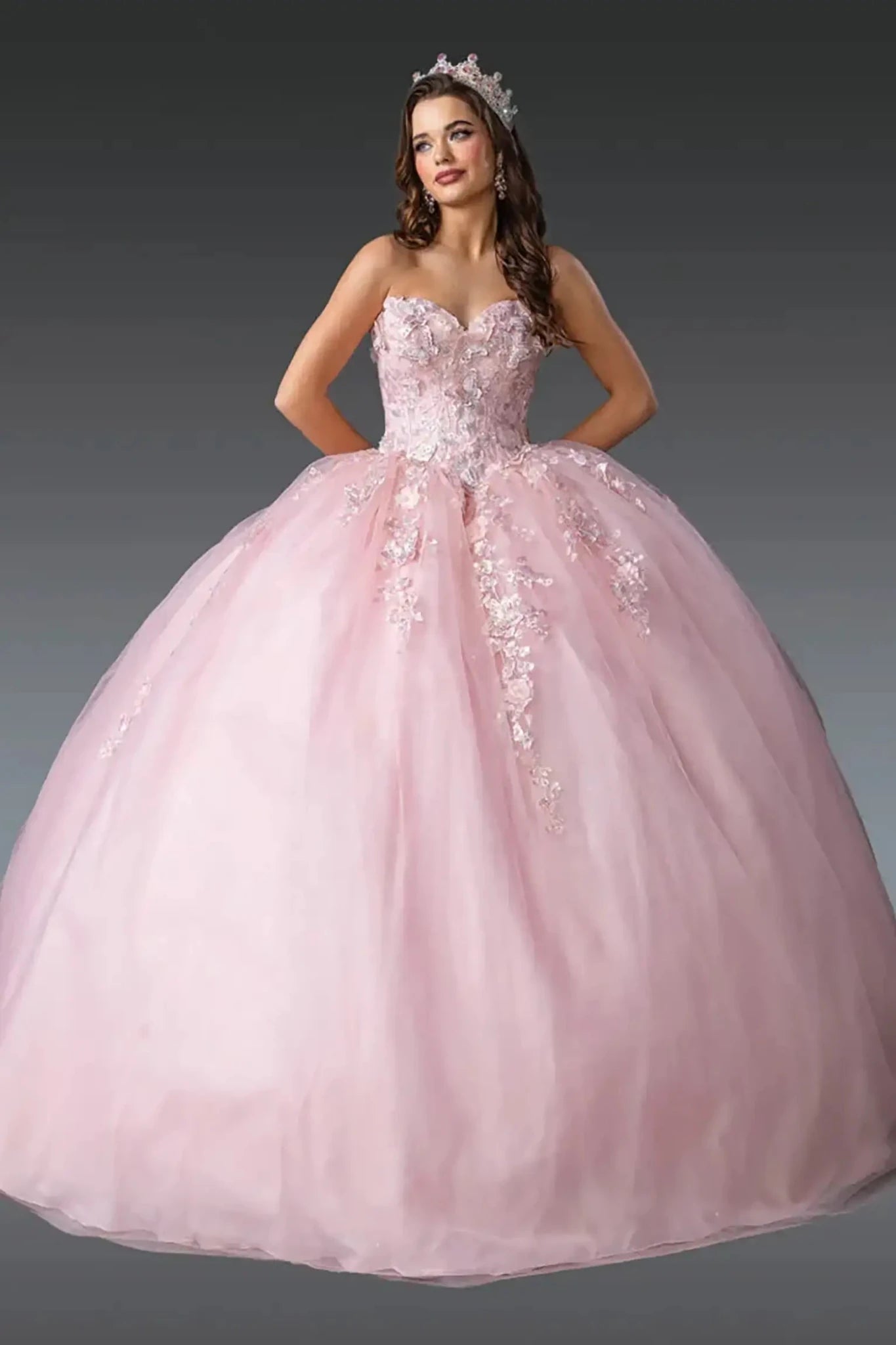 Front view: Blush pink quinceañera ball gown with strapless sweetheart corset bodice, floral lace appliqués, and full layered tulle skirt.