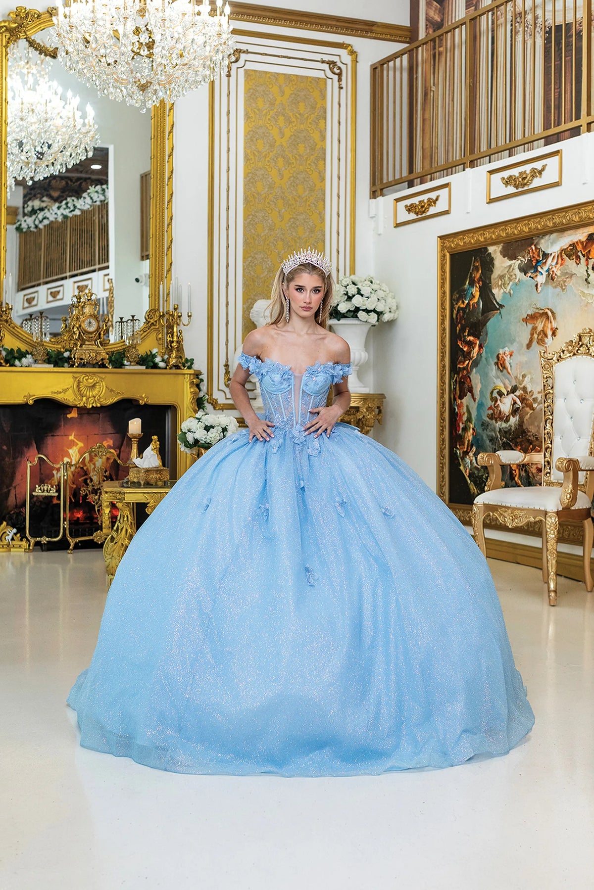 Front view of a Bahama Blue quinceañera gown with off-the-shoulder neckline, sheer corset bodice, floral appliqués, and glitter tulle skirt