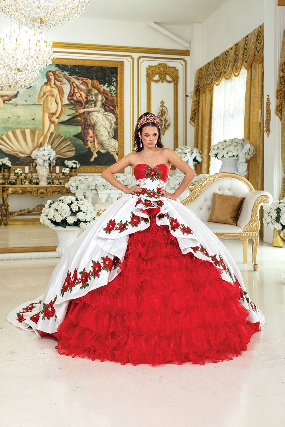 Woman standing front-facing in white and red strapless quinceañera ball gown with embroidered floral bodice, layered ruffled skirt, and butterfly accents