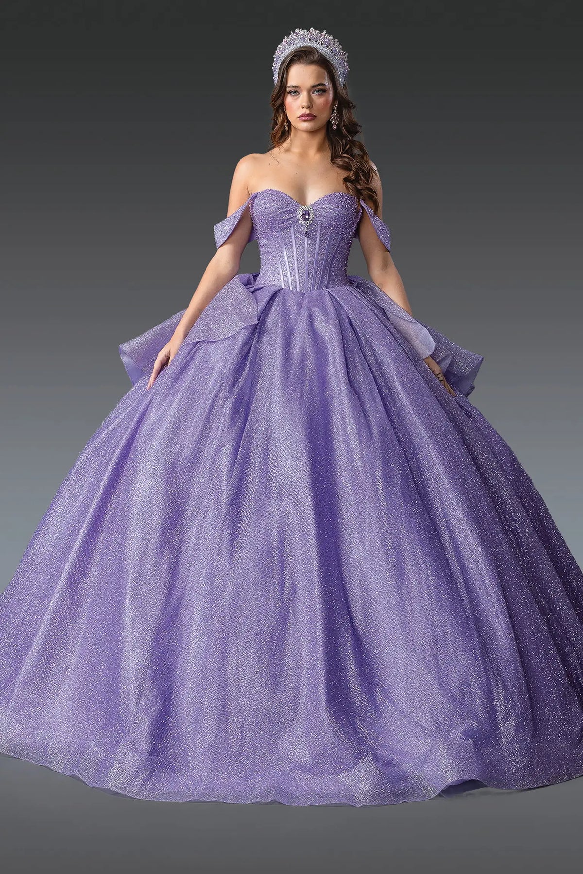 Showing a structured sweetheart bodice and glitter tulle skirt, this Lilac quinceañera ball gown is shown in full view.
