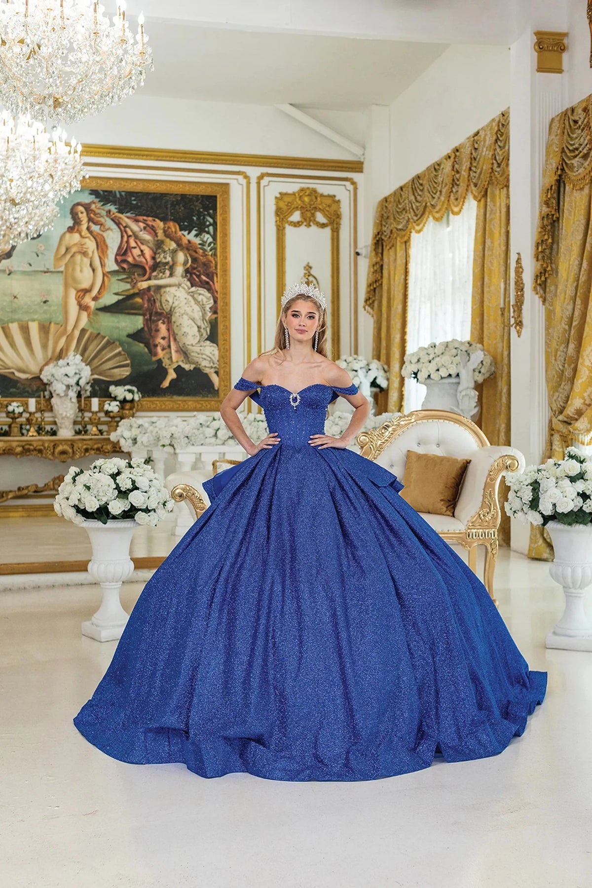 Showing a structured sweetheart bodice and glitter tulle skirt, this Royal Blue quinceañera ball gown is shown in full view.