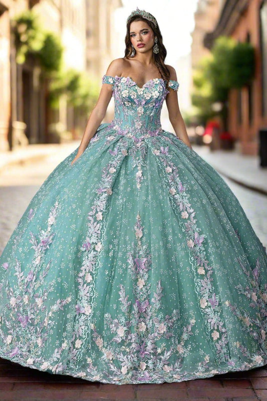 Woman standing front-facing in sage quinceañera ball gown with strapless bodice, embroidered floral accents, and layered ruffled voluminous skirt