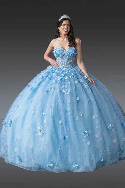 Woman standing front-facing in Bahama blue quinceañera ball gown with off-shoulder sleeves, beaded bodice, floral appliqué accents, and cascading glitter tulle skirt