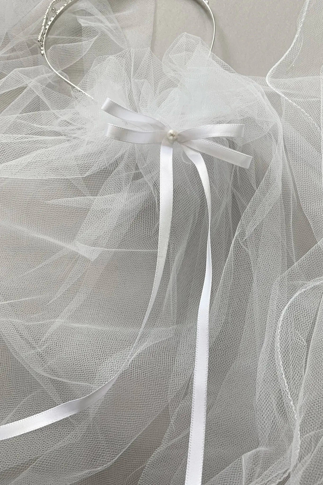 White rhinestone tulle flower girl and first communion tiara and two-tier veil.