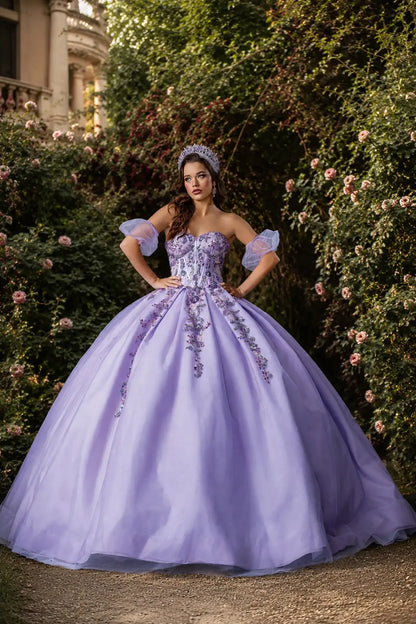 Front view of a lilac quinceanera dress with floral appliques, glittered fabric, detachable puff sleeves, and layered tulle skirt