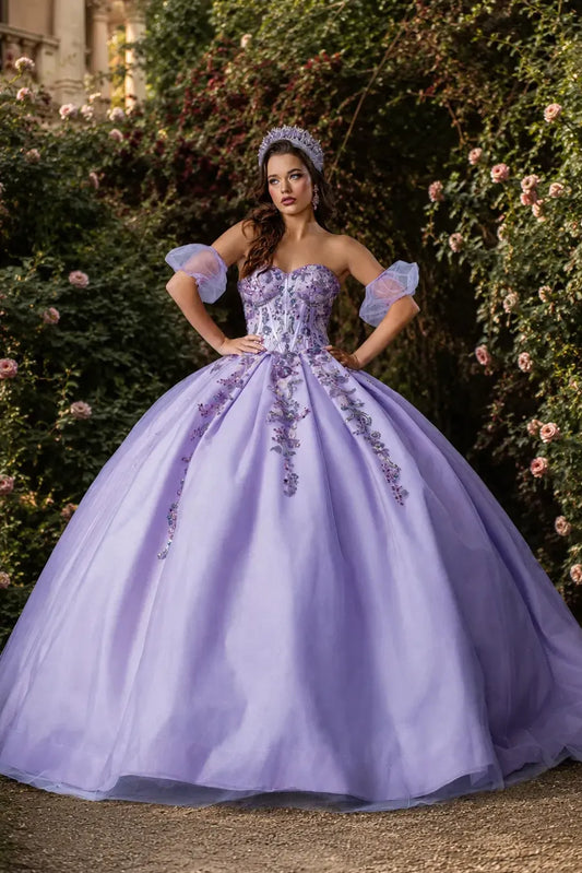 Front view of a lilac quinceanera dress with floral appliques, glittered fabric, detachable puff sleeves, and layered tulle skirt