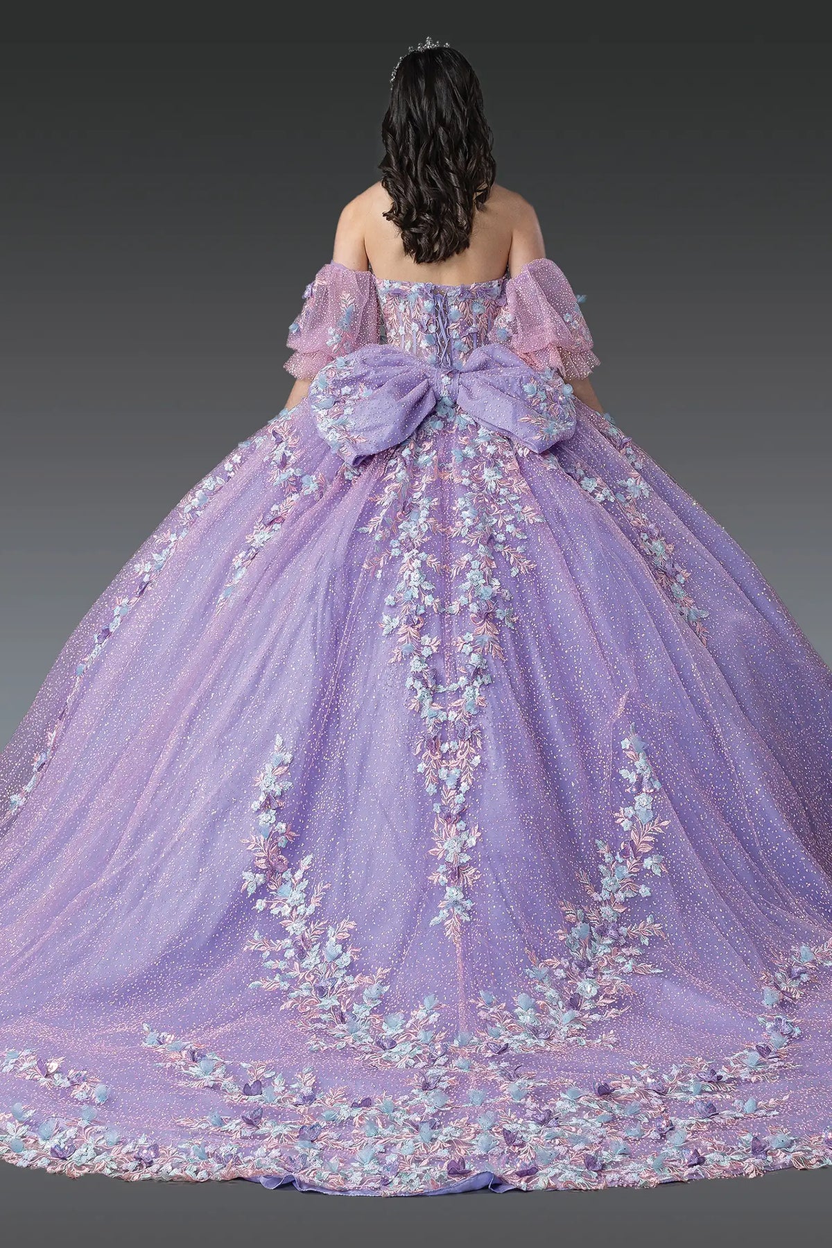 Back view of a Lilac/Multi Print quinceañera gown showing lace-up back, puff sleeves, and embroidered tulle skirt