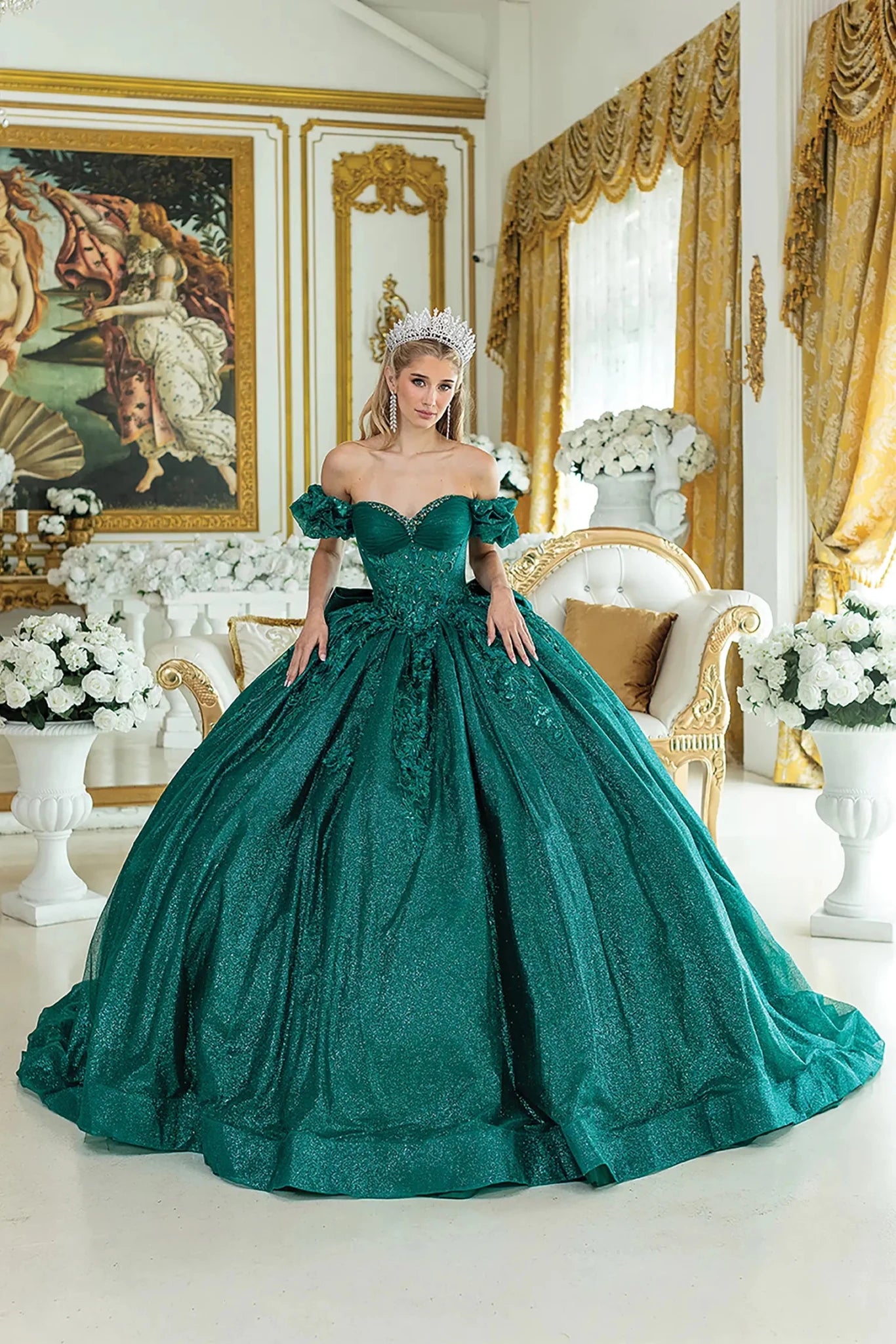 Woman standing front-facing in hunter green quinceañera ball gown with off-shoulder ruffled sleeves and intricately embroidered bodice