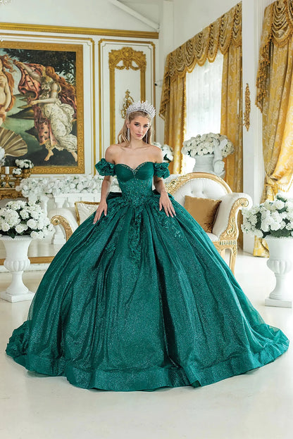 Woman standing front-facing in hunter green quinceañera ball gown with off-shoulder ruffled sleeves and intricately embroidered bodice