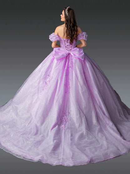 Woman standing back-facing in lilac quinceañera ball gown with off-shoulder sleeves, lace-up embroidered bodice, floral appliqués, and flowing sparkling skirt with train
