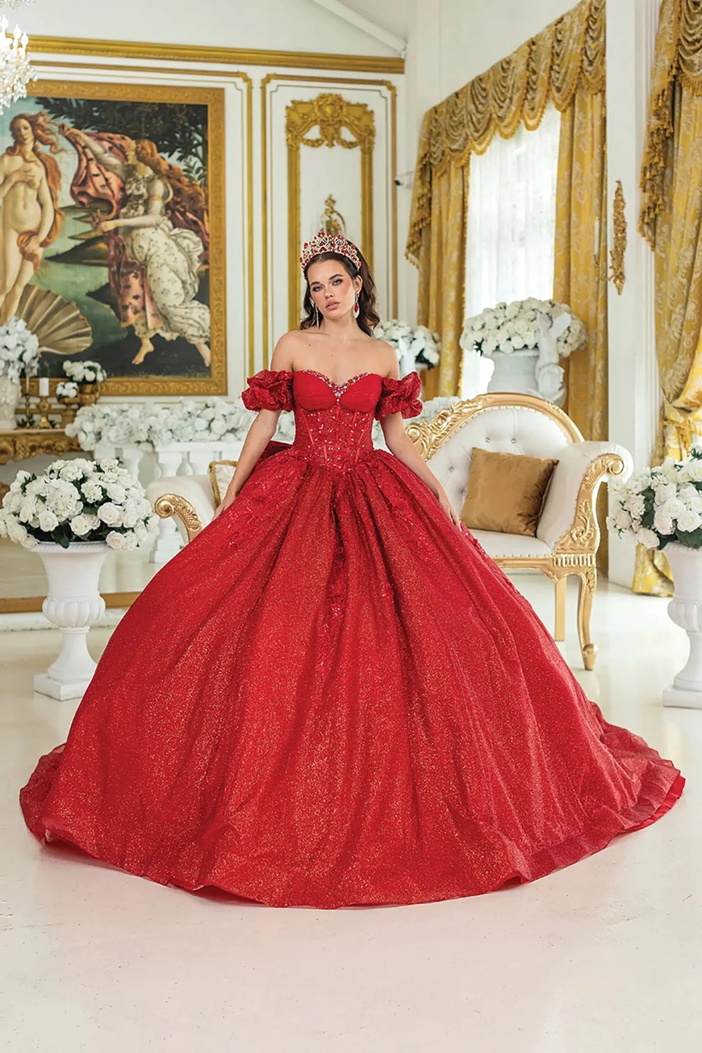 Woman standing front-facing in red quinceañera ball gown with off-shoulder sleeves, embroidered bodice, and voluminous layered skirt