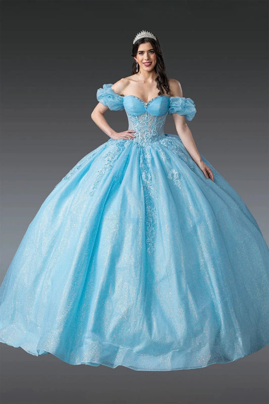 Woman standing front-facing in blue off-shoulder quinceañera ball gown with ruffled sleeves, embroidered bodice, and voluminous sparkling skirt