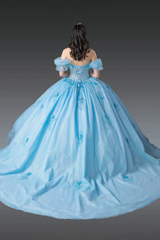 Woman standing back-facing in Bahama blue quinceañera ball gown with lace-up beaded bodice, off-shoulder sleeves, floral embellishments, and flowing glitter tulle skirt with train