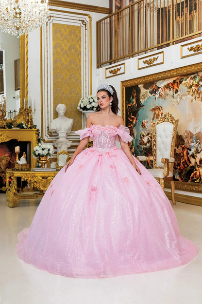Woman standing front-facing in pink quinceañera ball gown with deep V-neckline, embroidered floral accents, sheer overlay, and cascading layered skirt