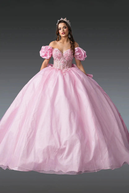 Woman standing front-facing in pink quinceañera ball gown with puff sleeves, floral embroidered bodice, fitted corset design, and voluminous layered tulle skirt