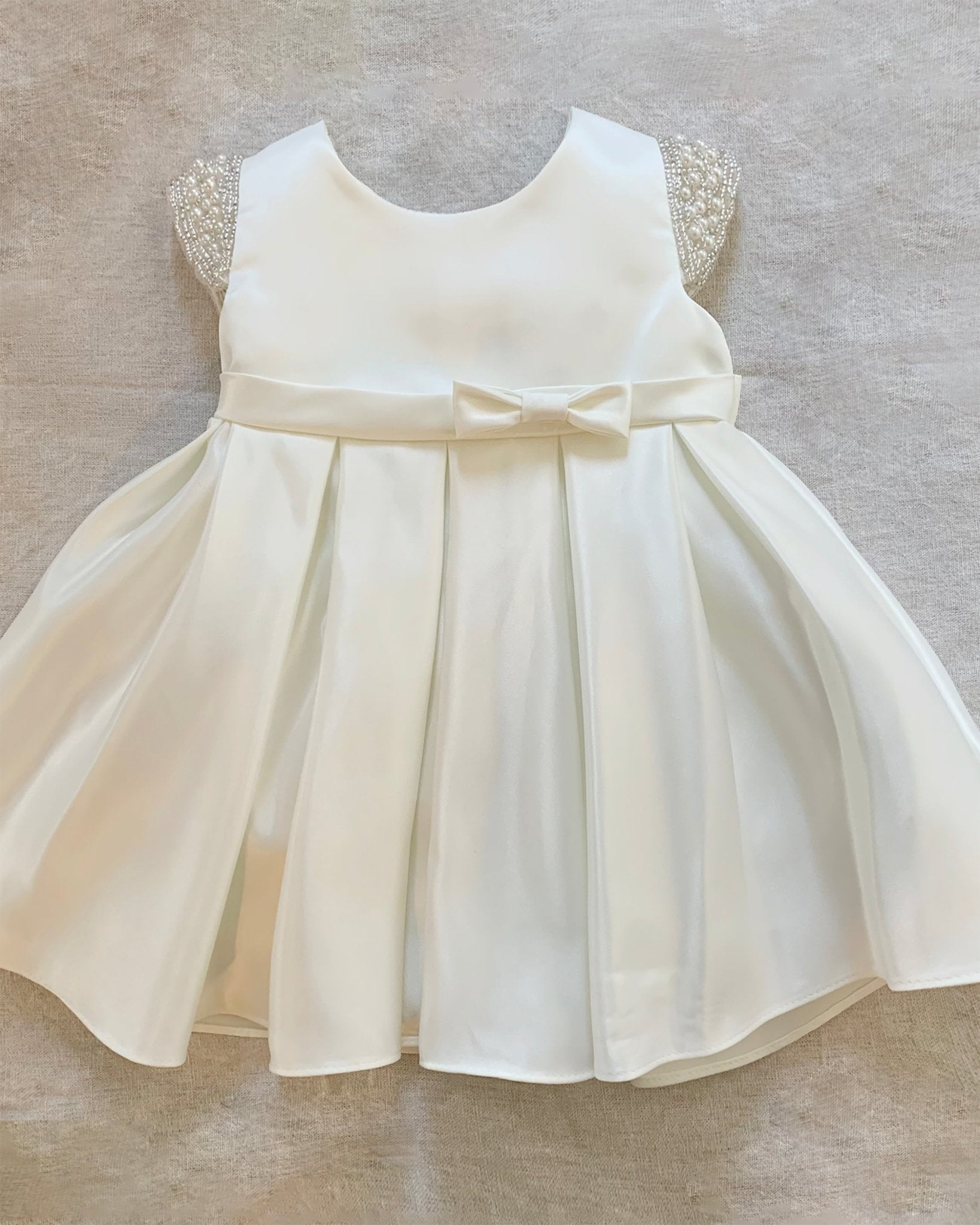 White flower girl dress with a bow.