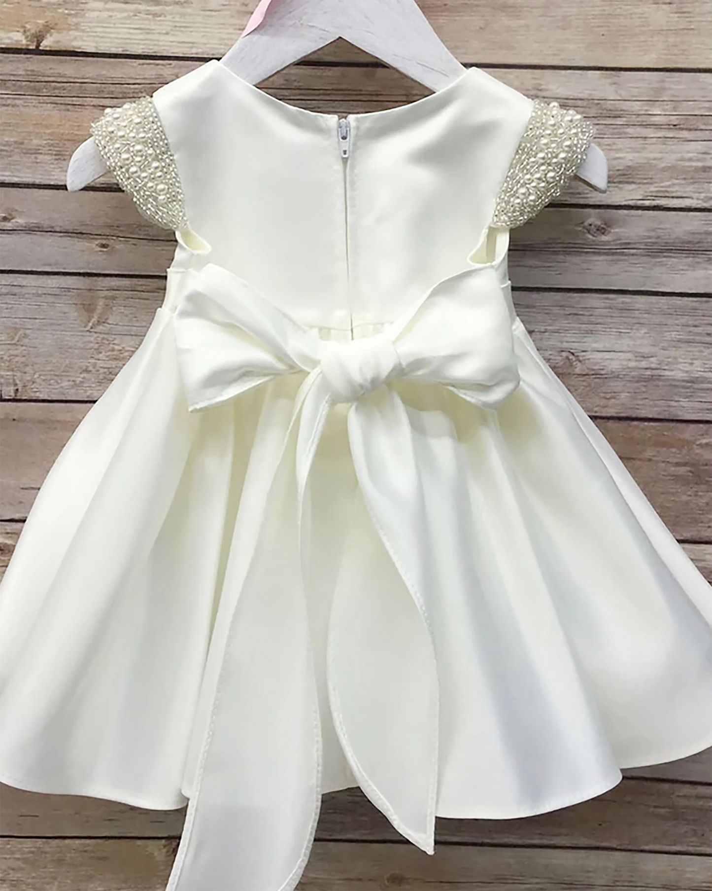 White flower girl dress with a large bow.