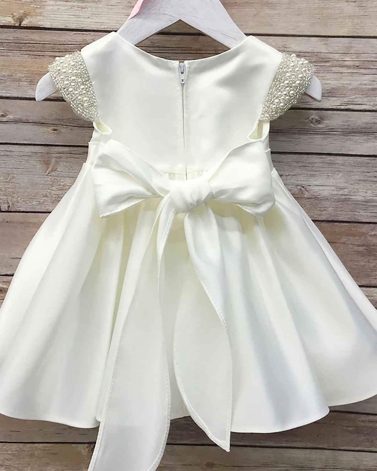 White flower girl dress with a large bow.