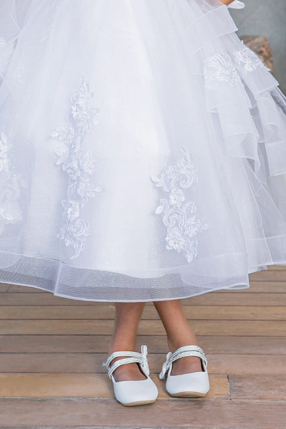 Layered tulle and flower appliques shape the White communion dress hem.