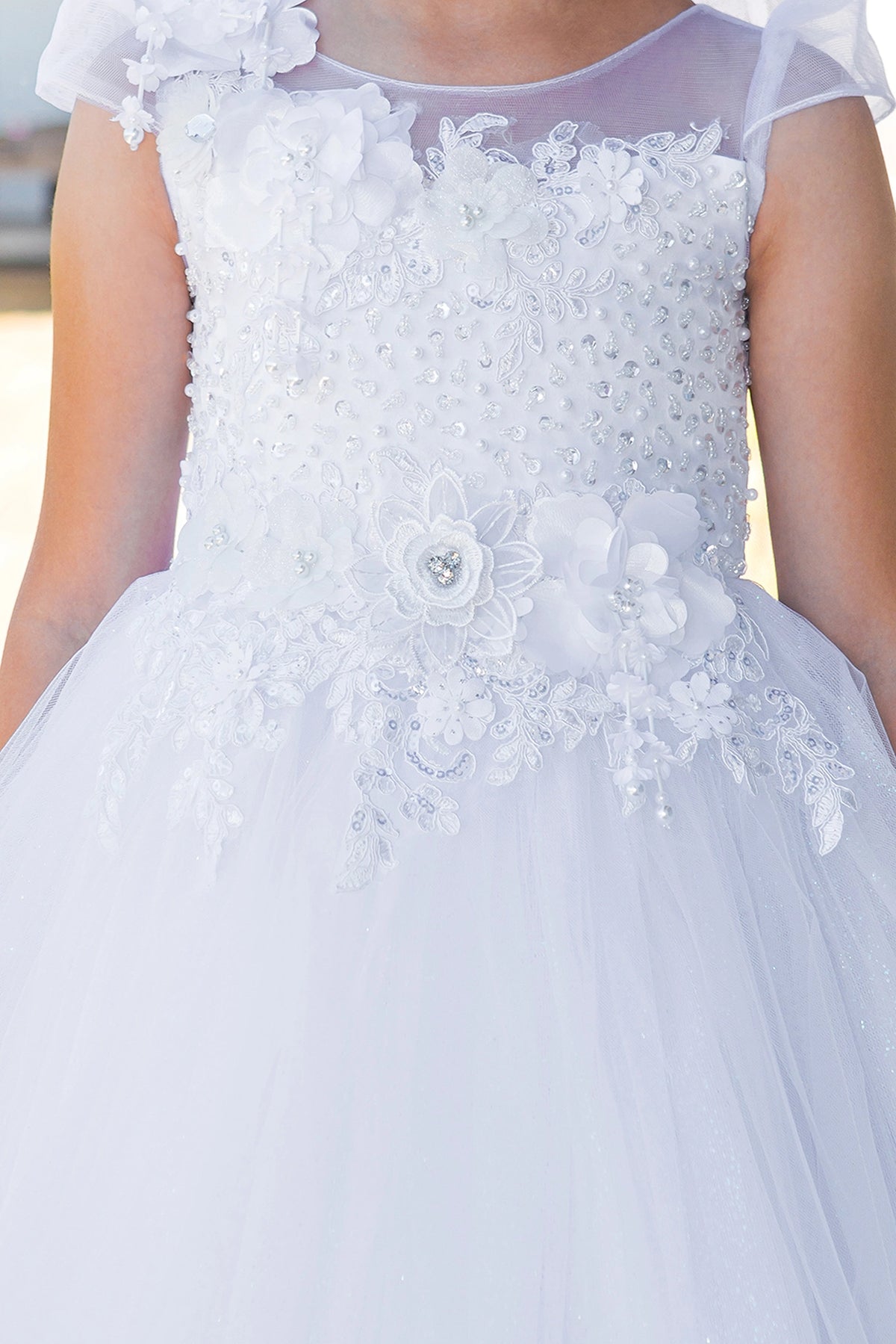 Dimensional flowers accent the illusion bodice on this White communion dress.