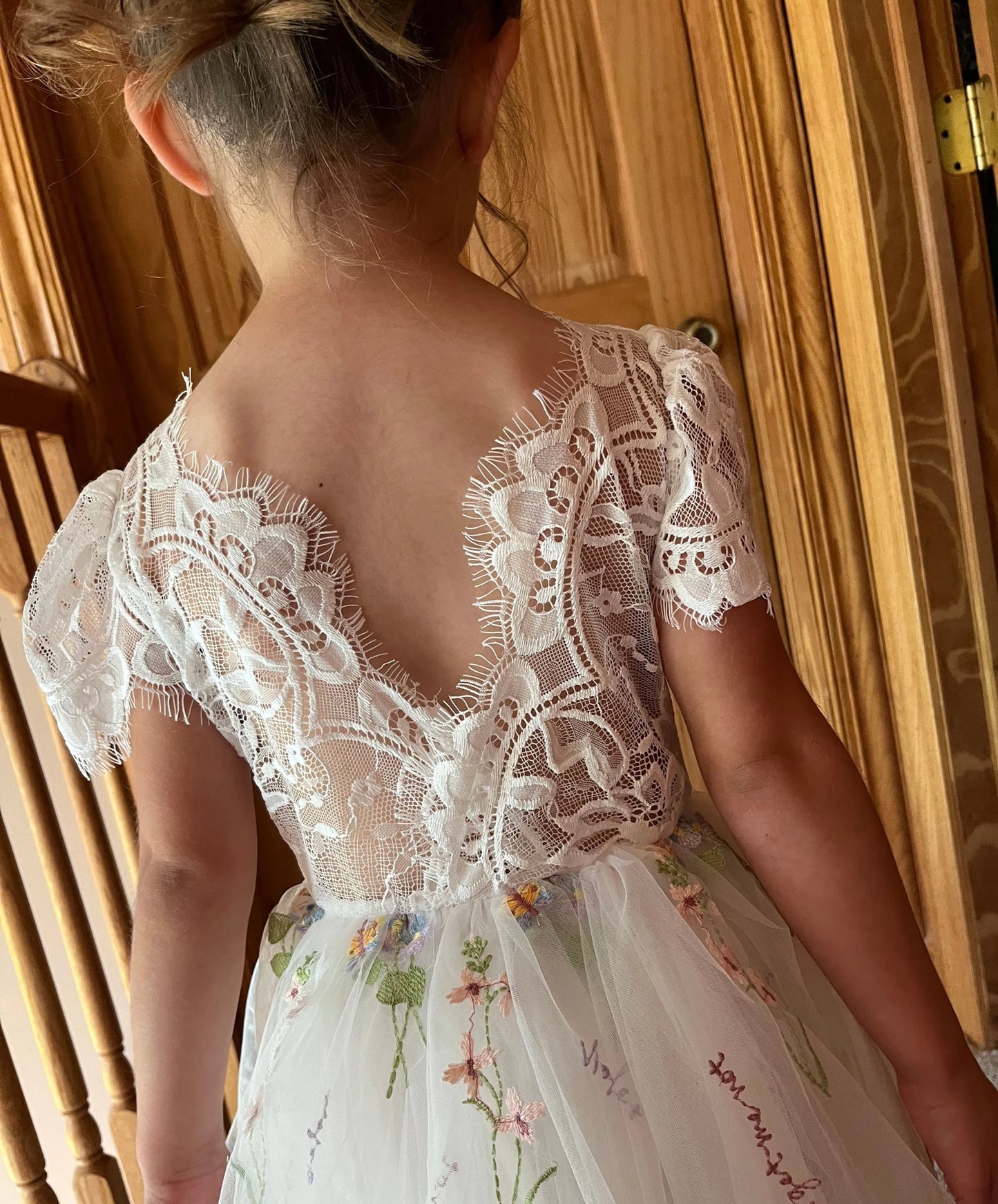 White lace flower girl dress with floral embroidery.