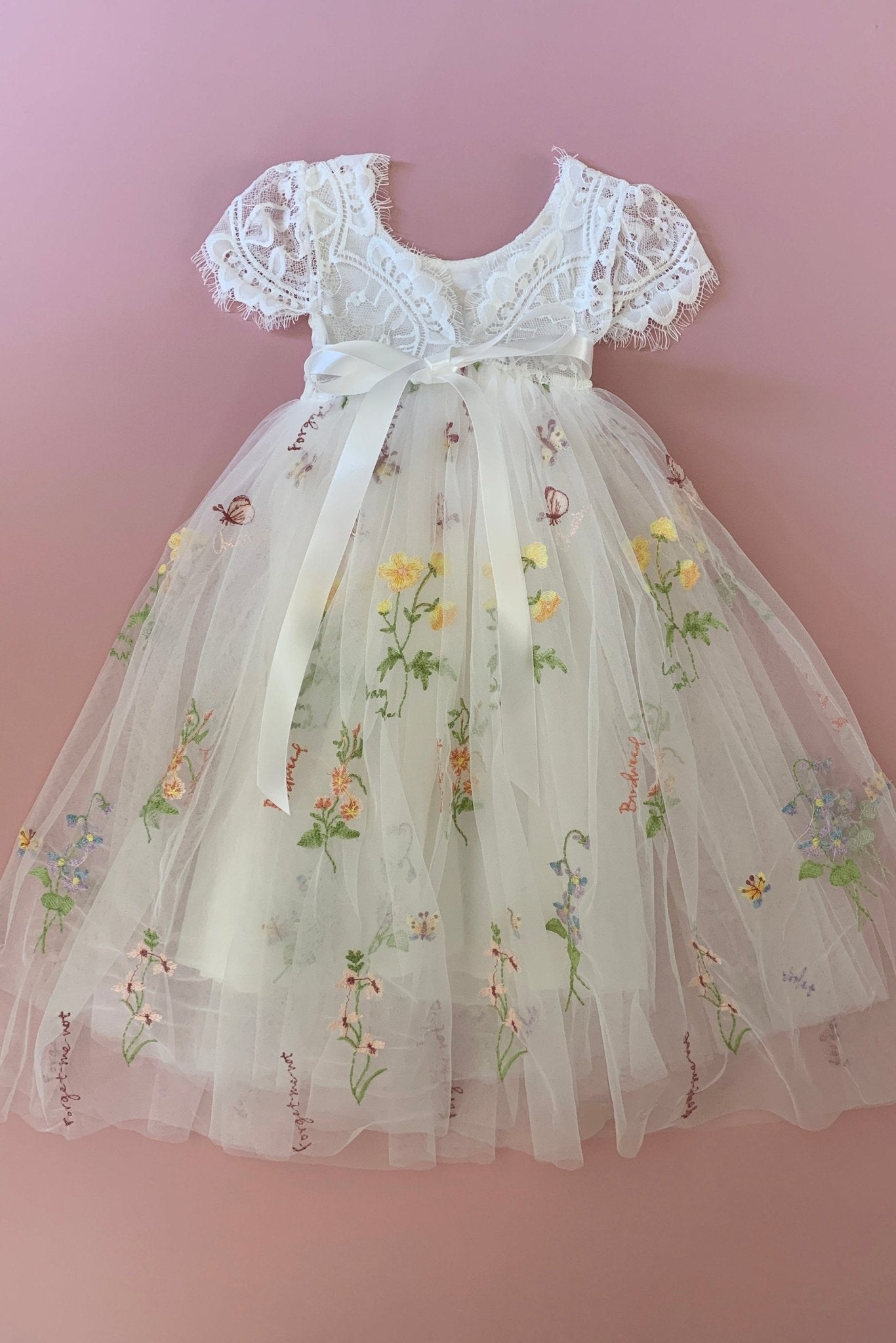 White lace flower girl dress with floral embroidery.