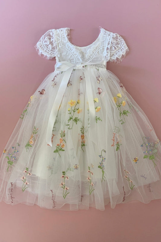 White lace flower girl dress with floral embroidery.