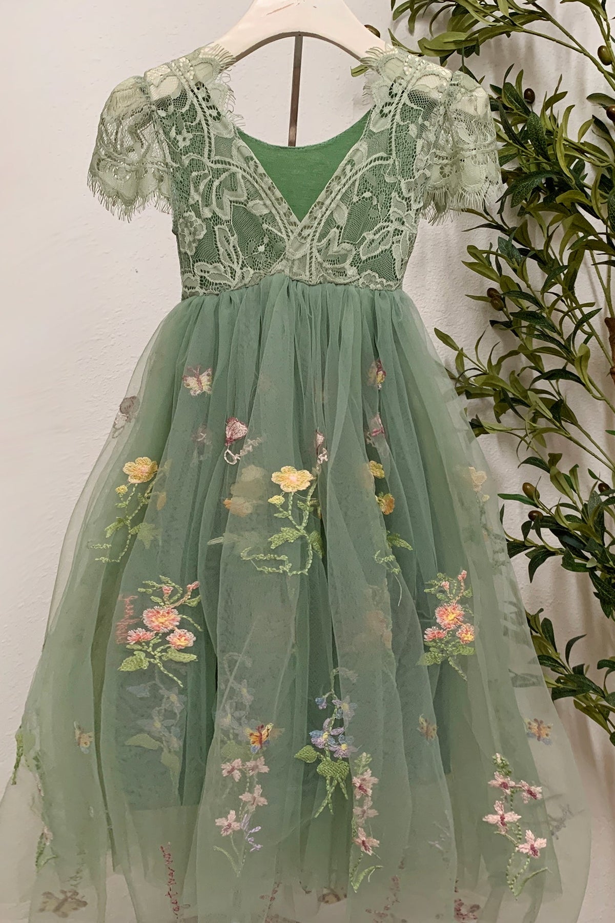 Sage lace tulle flower girl dress with floral and butterfly embroidery and cap sleeves v-back.
