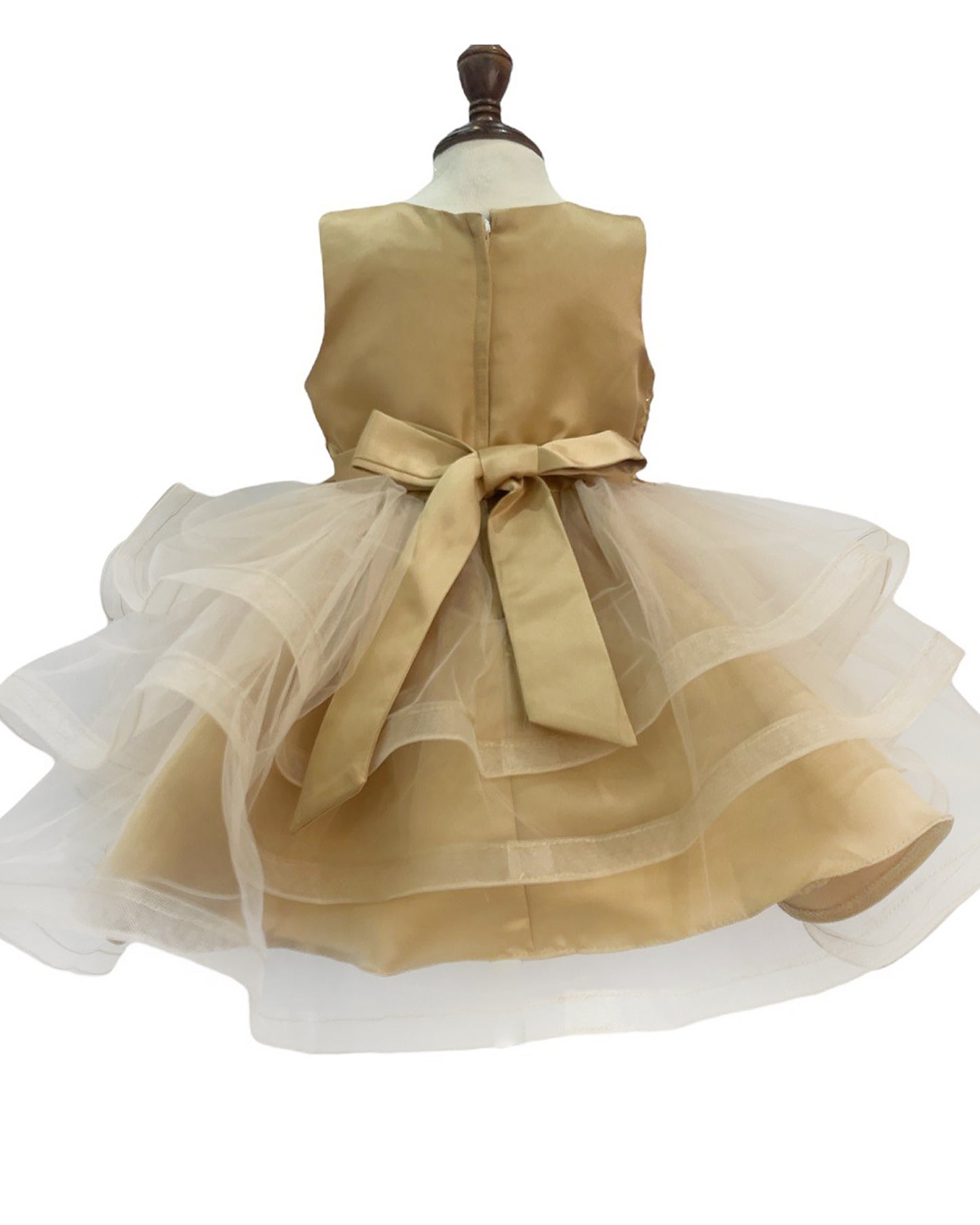 Champagne Gold dress with a large bow on a mannequin against a white background