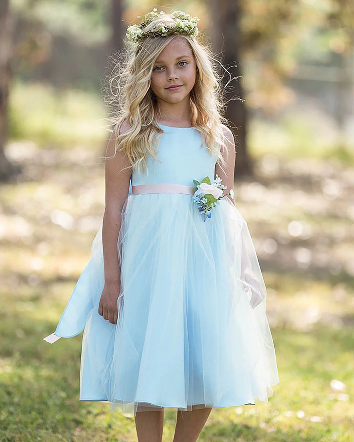 A light blue flower girl dress with a floral crown and bouquet.