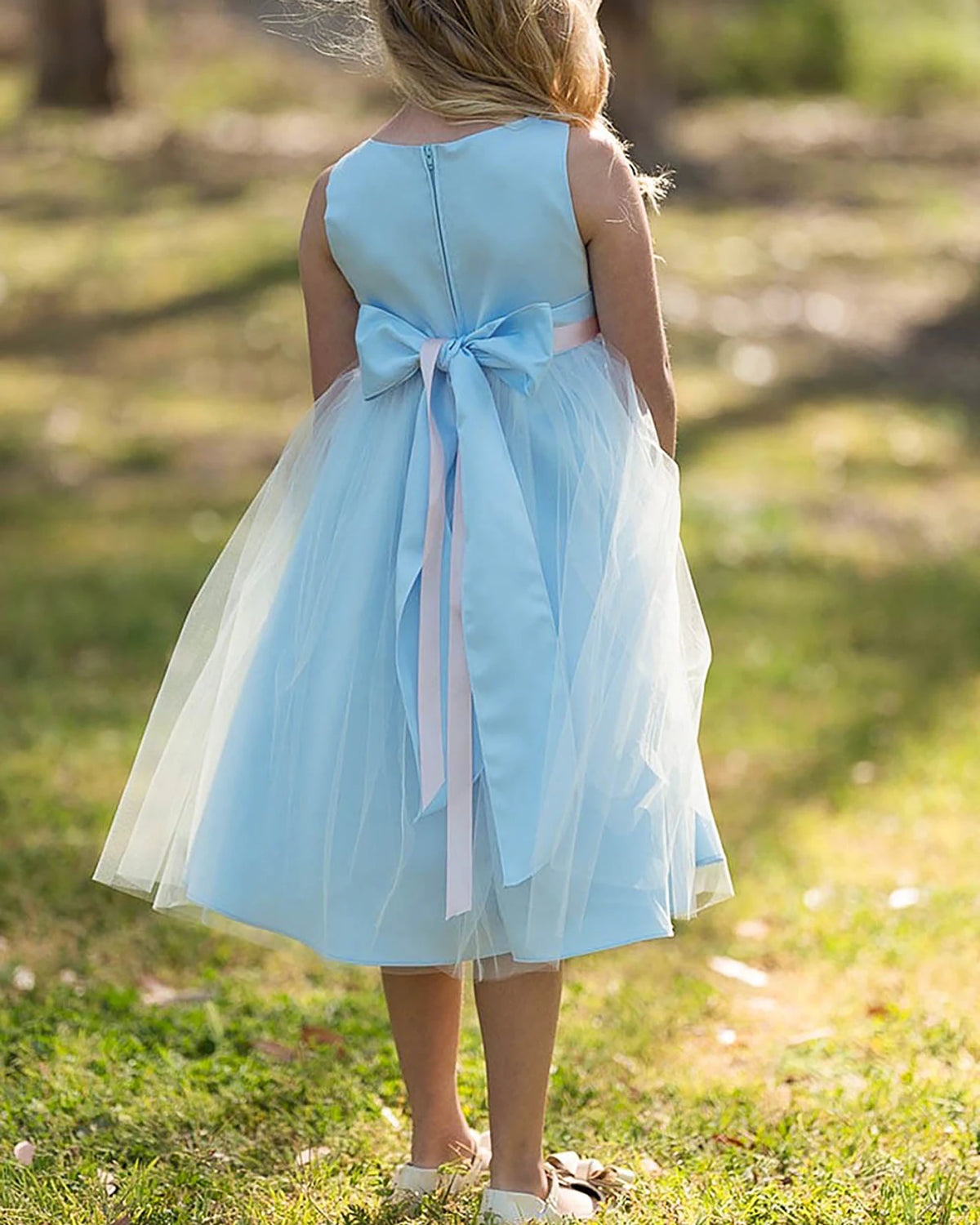 Light blue flower girl dress with a large bow.