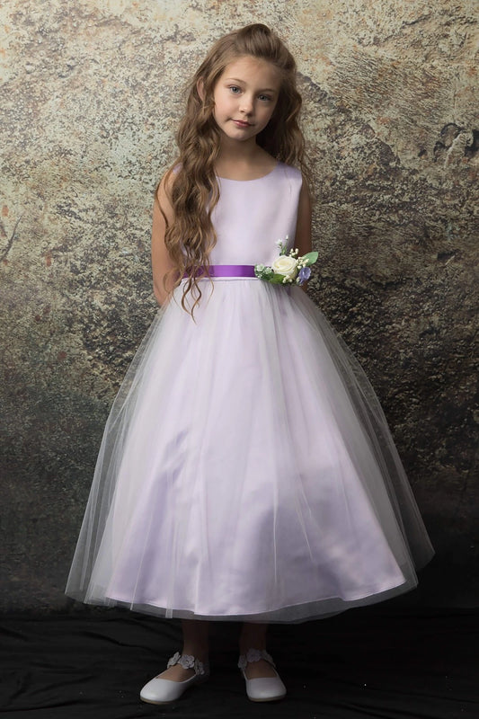 A lilac flower girl dress with a purple belt and white flower.