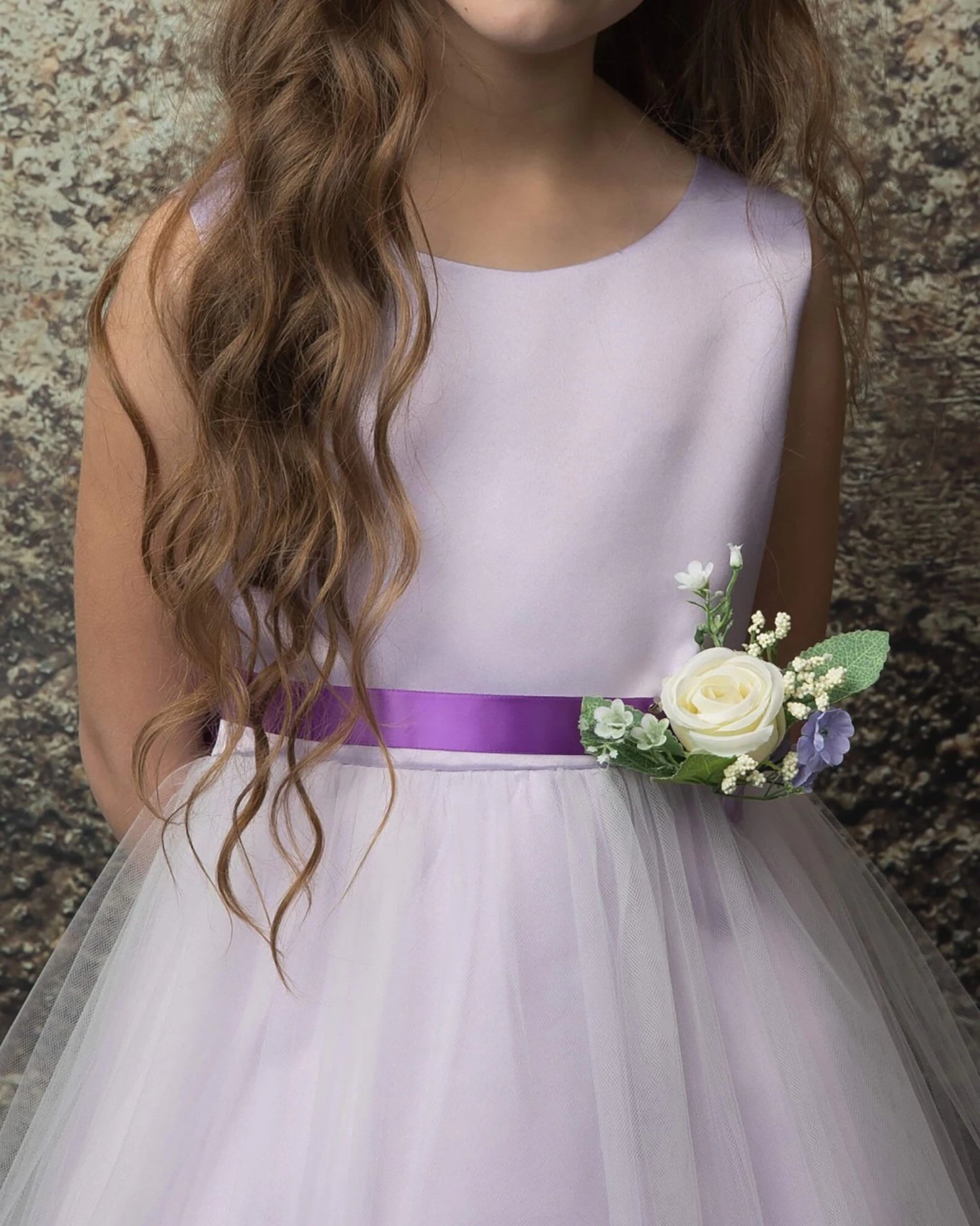 A lilac flower girl dress with a purple belt.