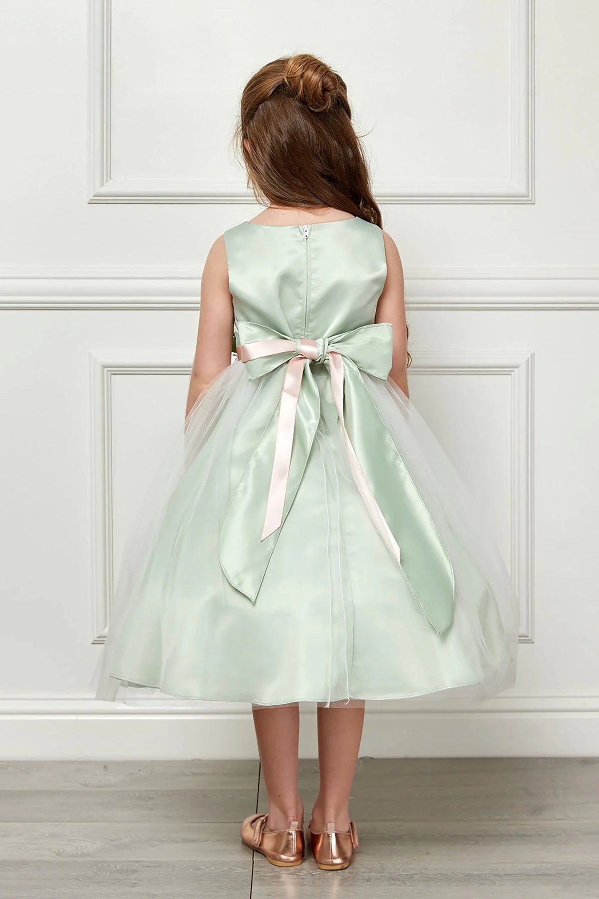 Decorative elements define a light Sage flower girl dress with a bow.