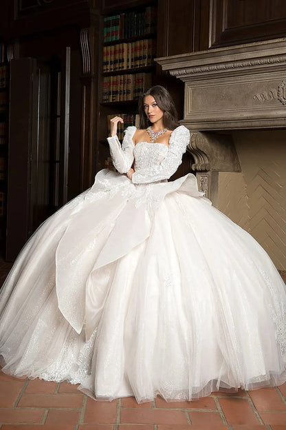 Woman in a white wedding dress sitting in a room with bookshelves and a fireplace.