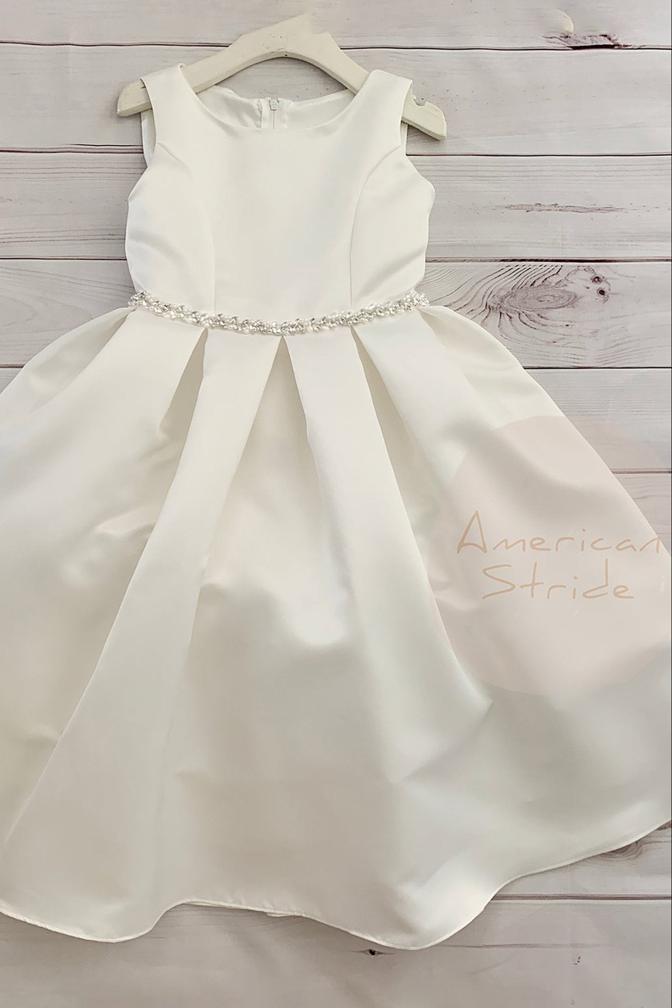 White satin flower girl dress with a beaded waistband, branded 'American Stride'. Also suitable as a communion dress. Also suitable as a baptism dress.